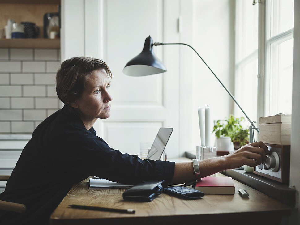 Im Notfall auf dem Laufenden bleiben Business-Frau dreht ihr Radio auf